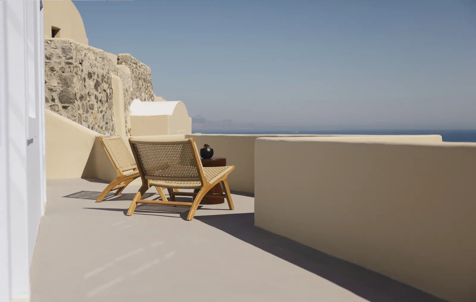 Terrasse der Red-Carpet Cove Suite mit zwei Stühlen und Meerblick