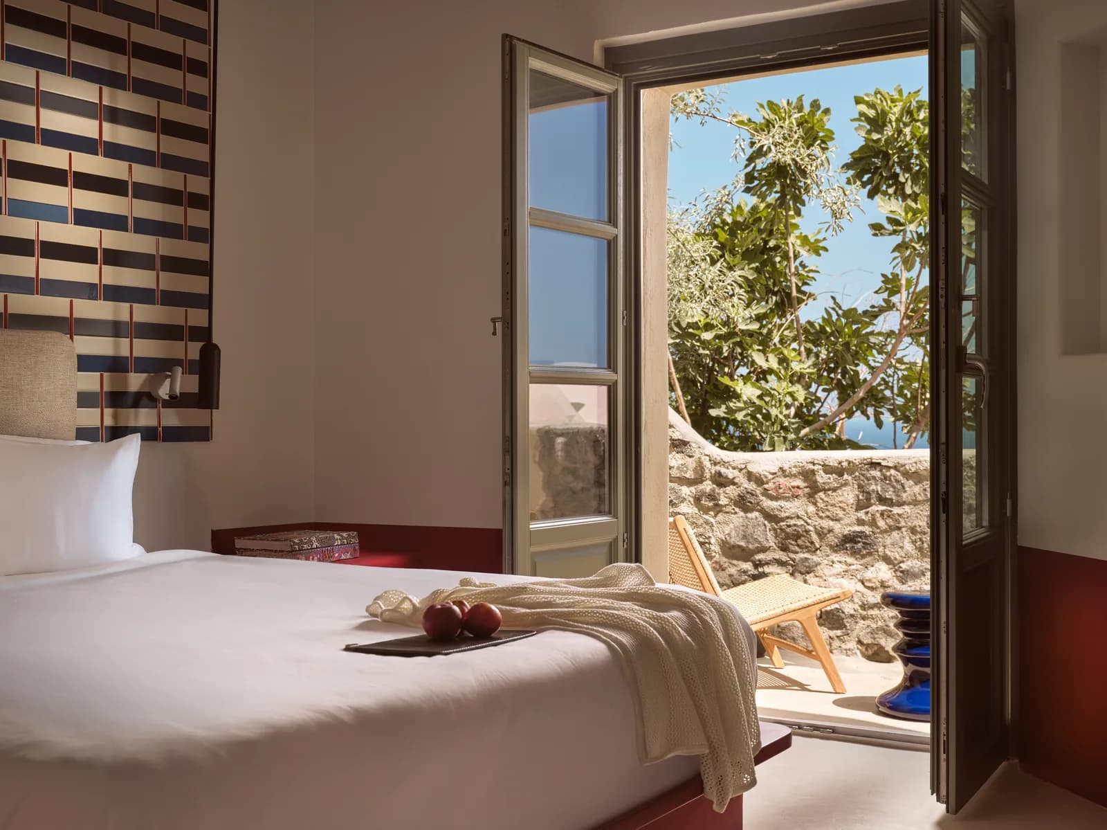 Zimmer Sarong Hideaway mit Doppelbett und offener Tür zum Garten