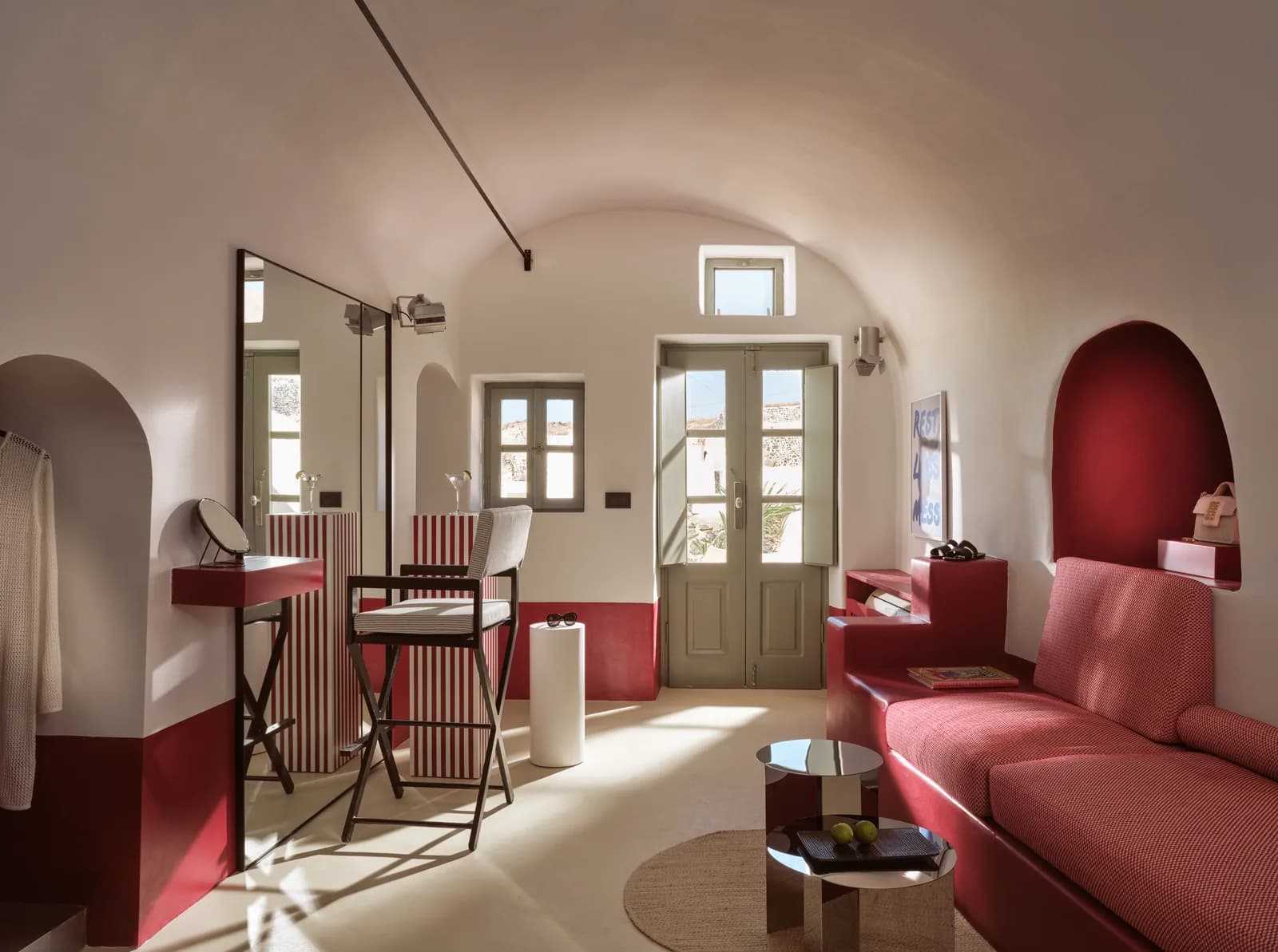 Gewölbter Wohnbereich der Sunhat Cove Suite mit rotem Sofa und Schminktisch